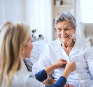 caretaker help the elderly get dressed