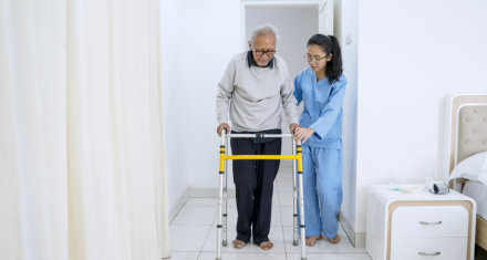 caretaker helps the elderly man